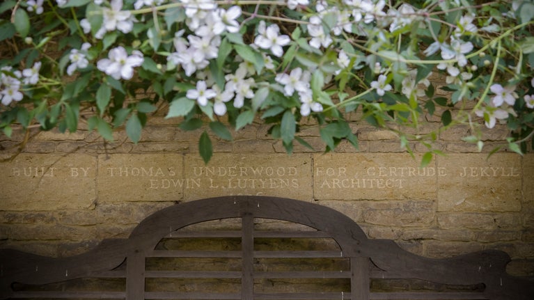 Detail view of an inscription in a stone wall at Munstead Wood.  The inscription reads "Built by Thomas Underwood for Gertrude Jekyll. Edwin L. Lutyens Architect. 1896"
